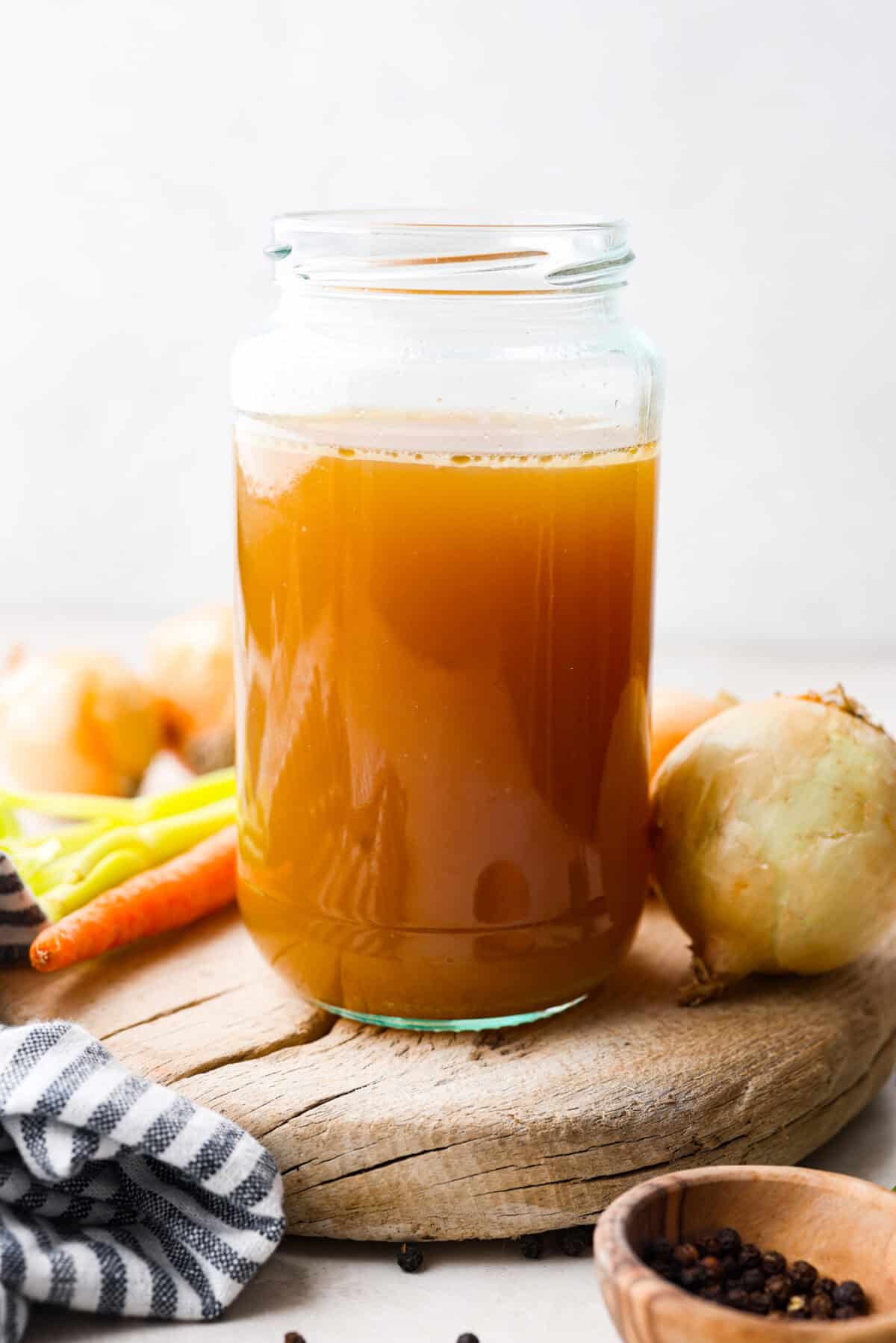 Learn how to make homemade bone broth with all of my top tips and tricks! This easy recipe is a simple combination of wholesome, nutritious ingredients. It's freezer-friendly and great for using in a variety of recipes, from soups, sauces and gravies to casseroles and rice. Side shot of a mason jar with homemade bone broth in it.