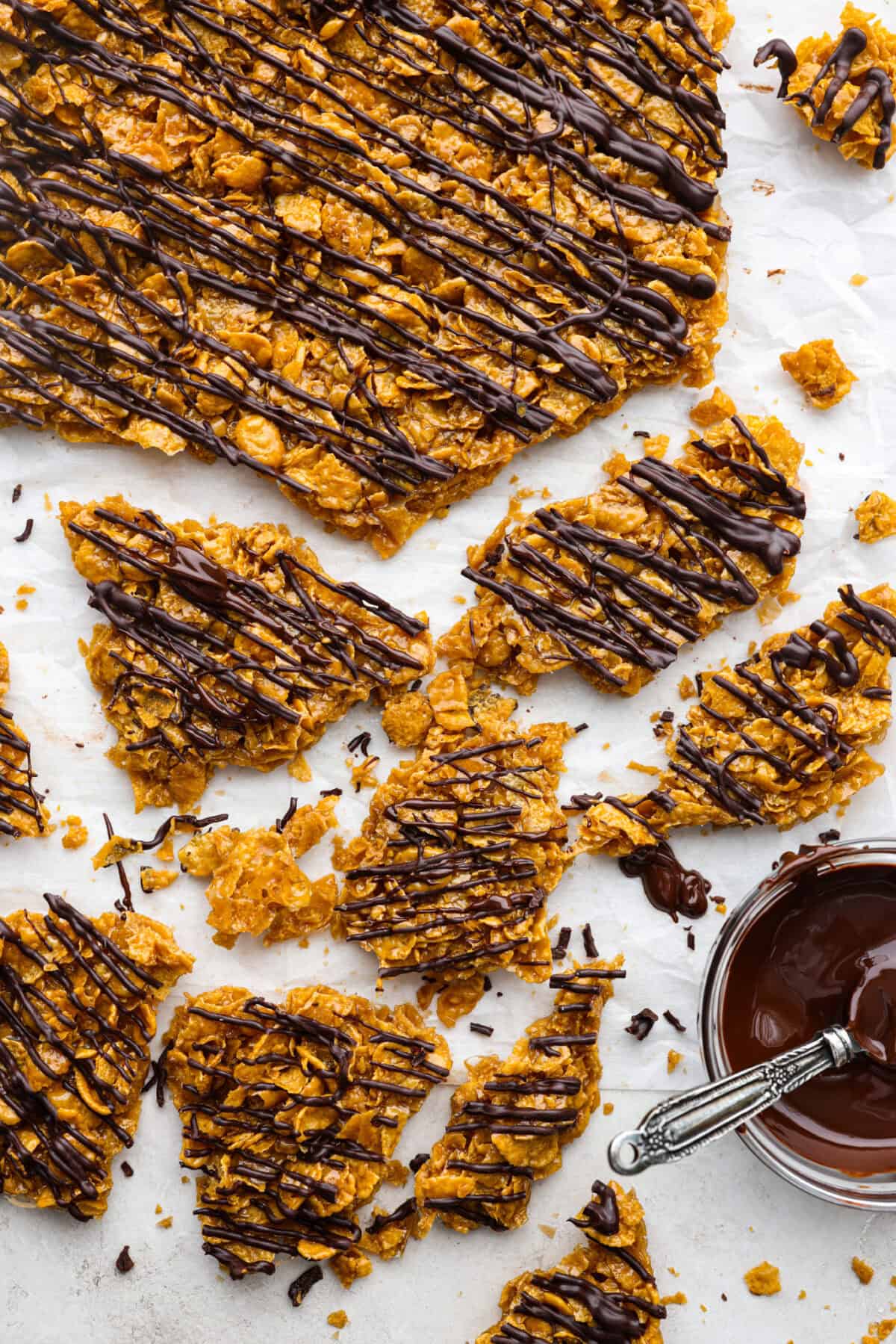 This cornflake brittle crack is crispy, chewy and to die for! With only six ingredients and 8 minutes of prep, you can have this yummy treat ready in no time. This brittle is crunchy cornflakes mixed with a buttery caramel sauce and drizzled in rich dark chocolate. Overhead shot of crunched up pieces of cornflake brittle crack.