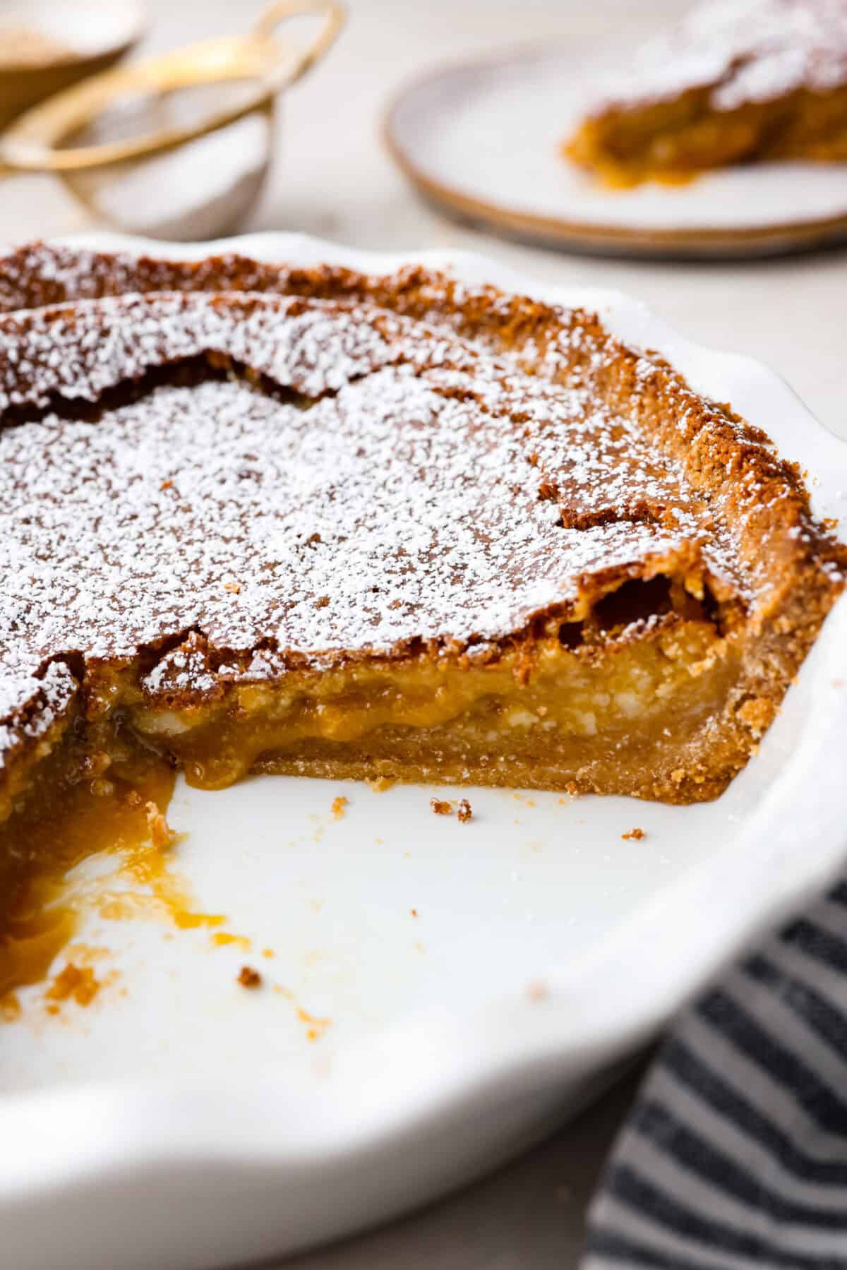 Delicious and addicting, the famous Crack Pie is what made Milk Bar bakery so popular. This copycat recipe is made with a sweet and salty filling tucked inside a crispy oat cookie crust. It’s so good you won’t be able to stop eating it! Angle shot of a slice cut out of the crack pie.