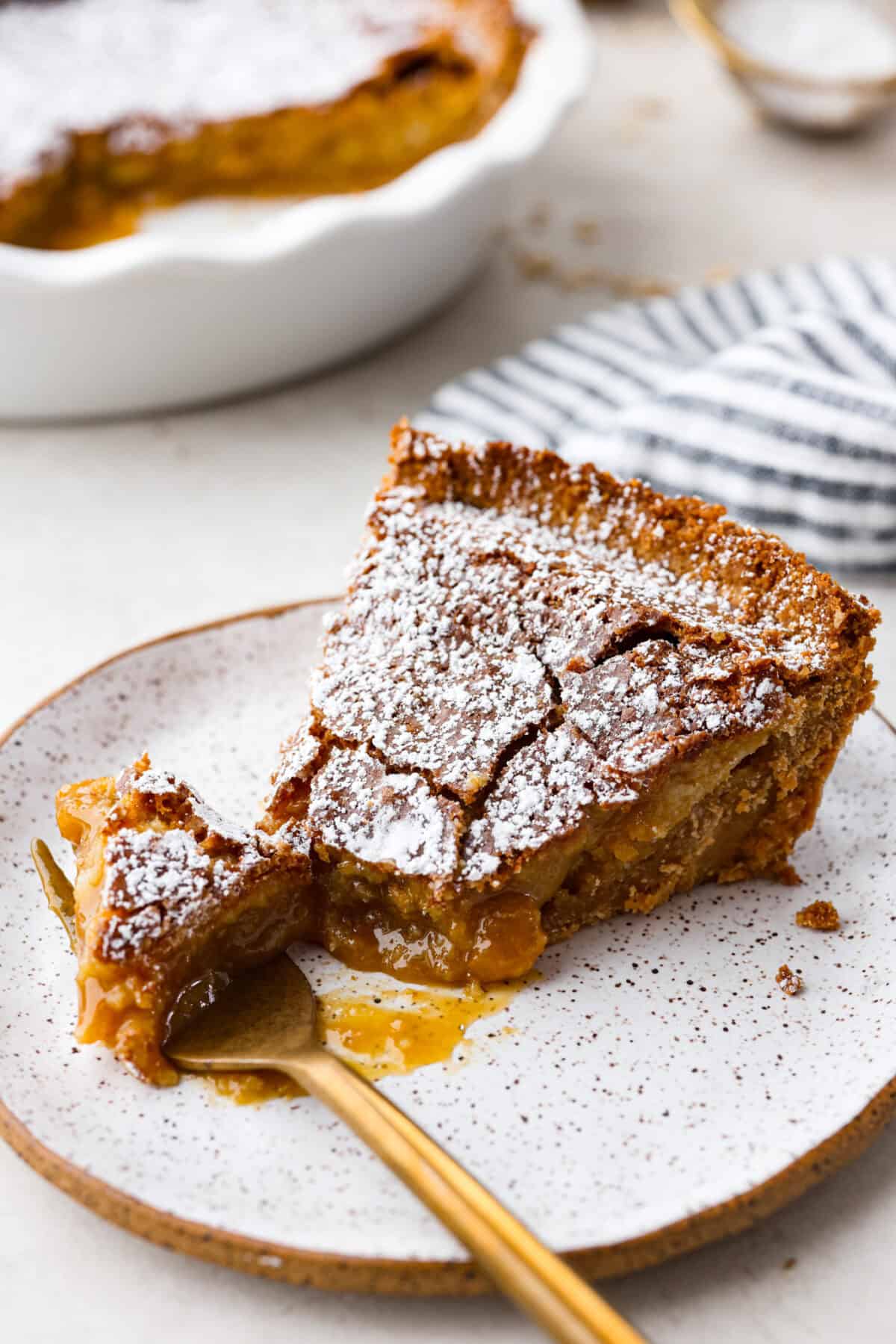 Delicious and addicting, the famous Crack Pie is what made Milk Bar bakery so popular. This copycat recipe is made with a sweet and salty filling tucked inside a crispy oat cookie crust. It’s so good you won’t be able to stop eating it! Angle shot of a slice of crack pie with a bite on a fork.