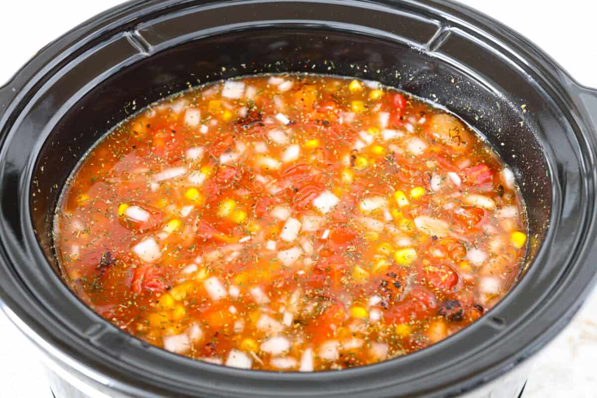 Crockpot buffalo chicken chili is a buffalo wing lover's dream. It has a tangy, fiery buffalo hot sauce base mixed with shredded chicken, smooth cream cheese, tender beans, and vegetables. If you love buffalo wings, you will love this chili! Overhead shot of all the ingredients stirred up in the crockpot.