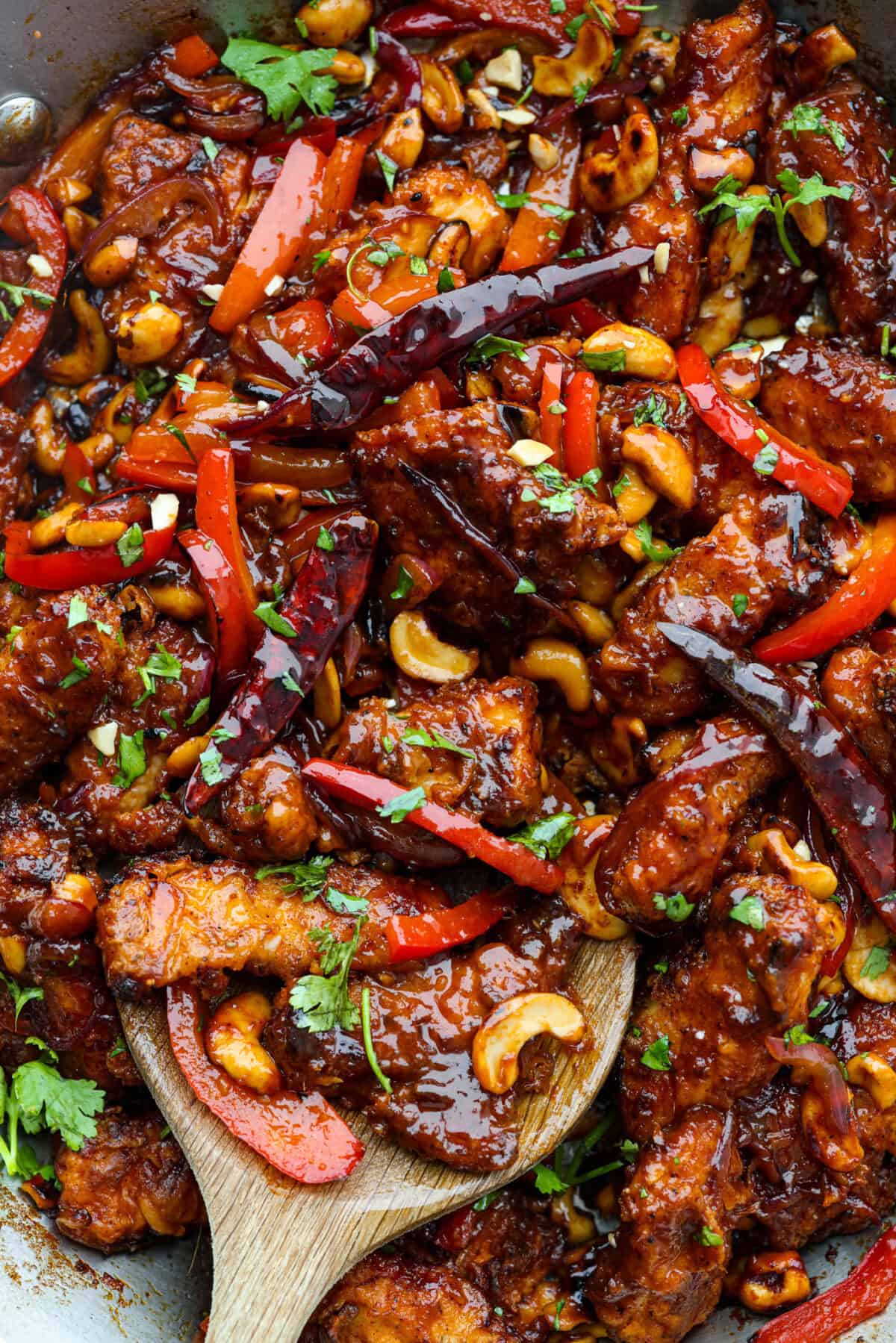 Dragon Chicken is a spicy and flavorful dish featuring tender breaded chicken stir-fried with vegetables and coated in a rich, tangy, and slightly sweet sauce. It's a crowd favorite for those who enjoy a fiery twist on the classic stir-fry! Close up shot of dragon chicken.