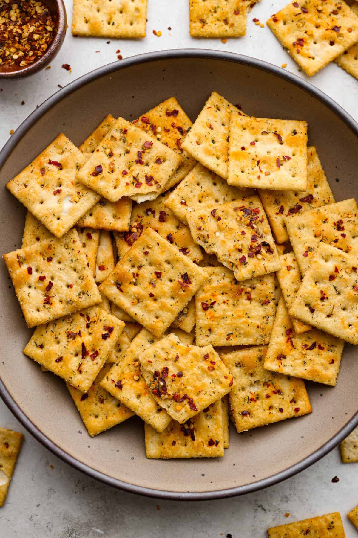 Get the party started with Fire Crackers! In this recipe, saltine crackers are transformed from something ordinary into something extraordinary with a flavorful blend of seasonings. They're easy to make and perfect for snacking on around the holidays (or anytime)! Overhead shot of a bowl of Fire Crackers.