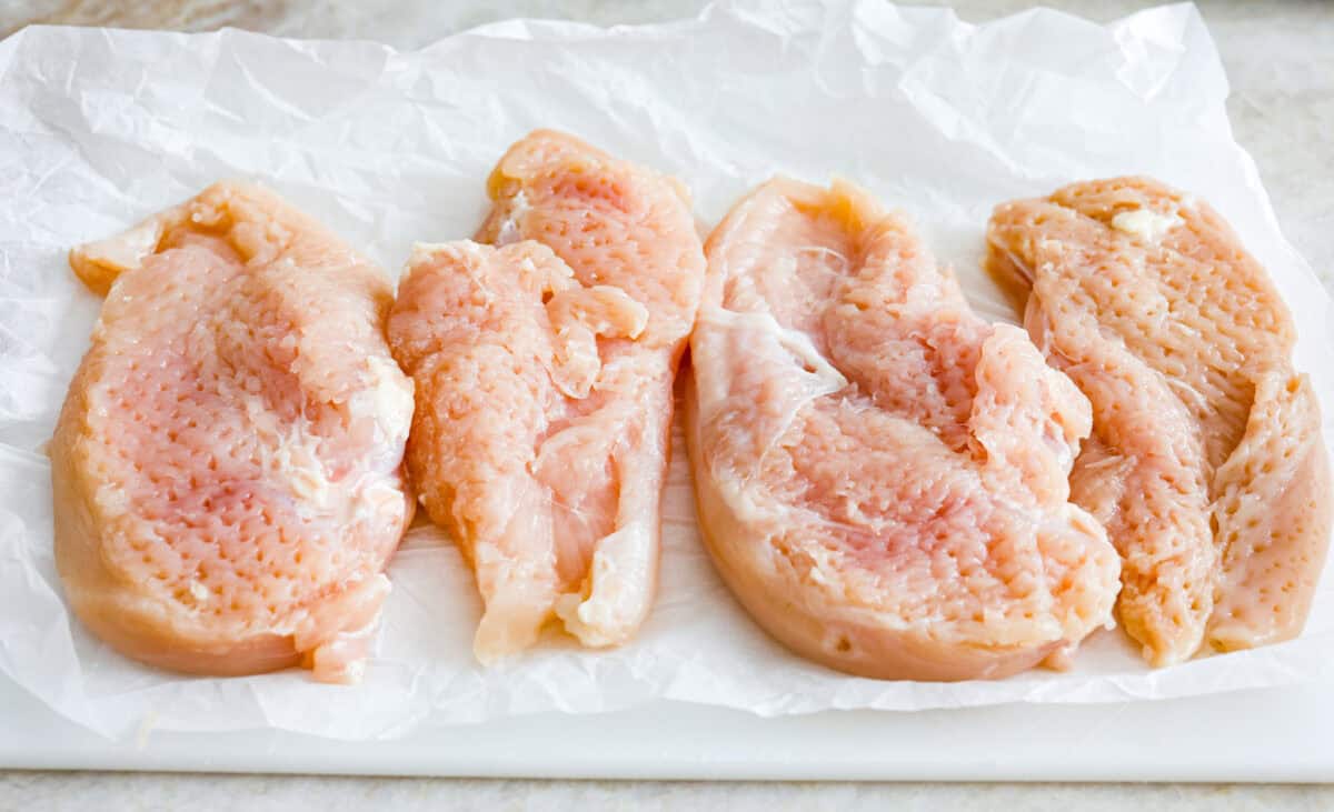 Garlic Butter Chicken is a rich and flavorful one-pan recipe that's on the dinner table in just 30 minutes! Well-seasoned, tender chicken breasts are pan-seared and then nestled in a simple yet tasty sauceย made with vinegar, broth, butter, shallots, and plenty of garlic. Overhead shot of chicken breasts tenderized.