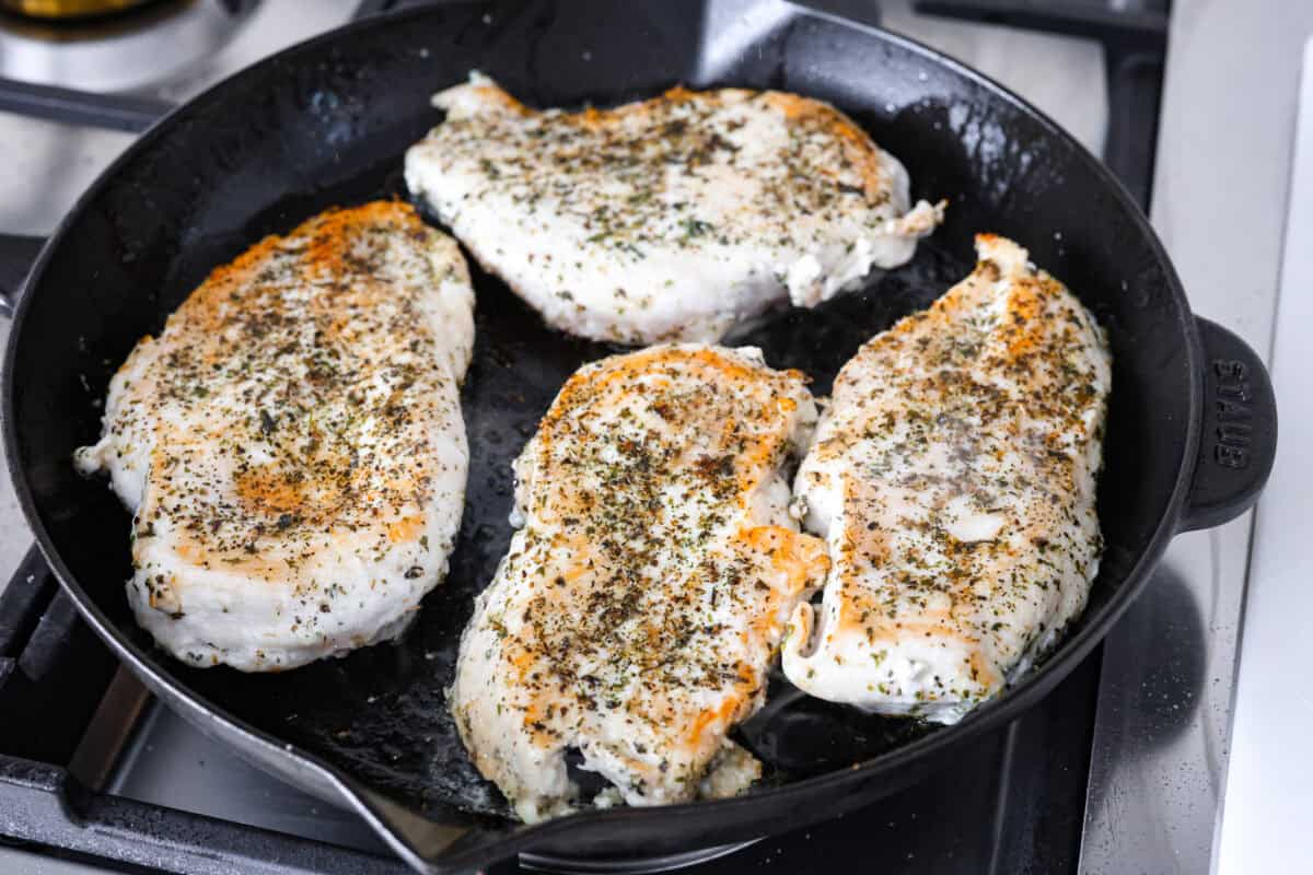 Garlic Butter Chicken is a rich and flavorful one-pan recipe that's on the dinner table in just 30 minutes! Well-seasoned, tender chicken breasts are pan-seared and then nestled in a simple yet tasty sauceย made with vinegar, broth, butter, shallots, and plenty of garlic. Angle shot of chicken breast searing in a skillet.