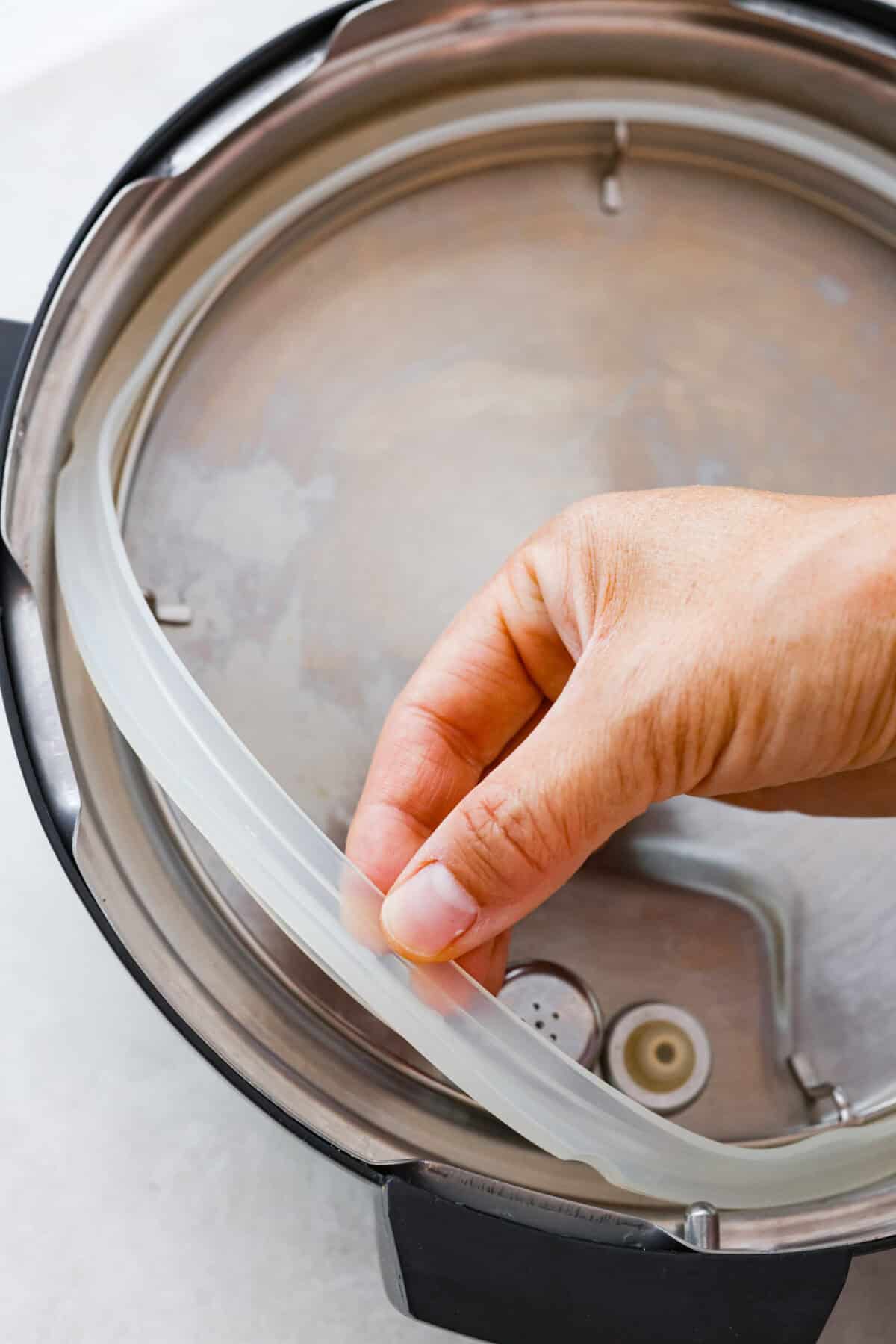 STOP being scared of your Instant Pot! This beginner's guide on How to Use an Instant Pot will help you feel comfortable and confident when using this magical kitchen appliance. It makes cooking fast, easy, and convenient. Sixth photo of the silicone seal ring being removed.