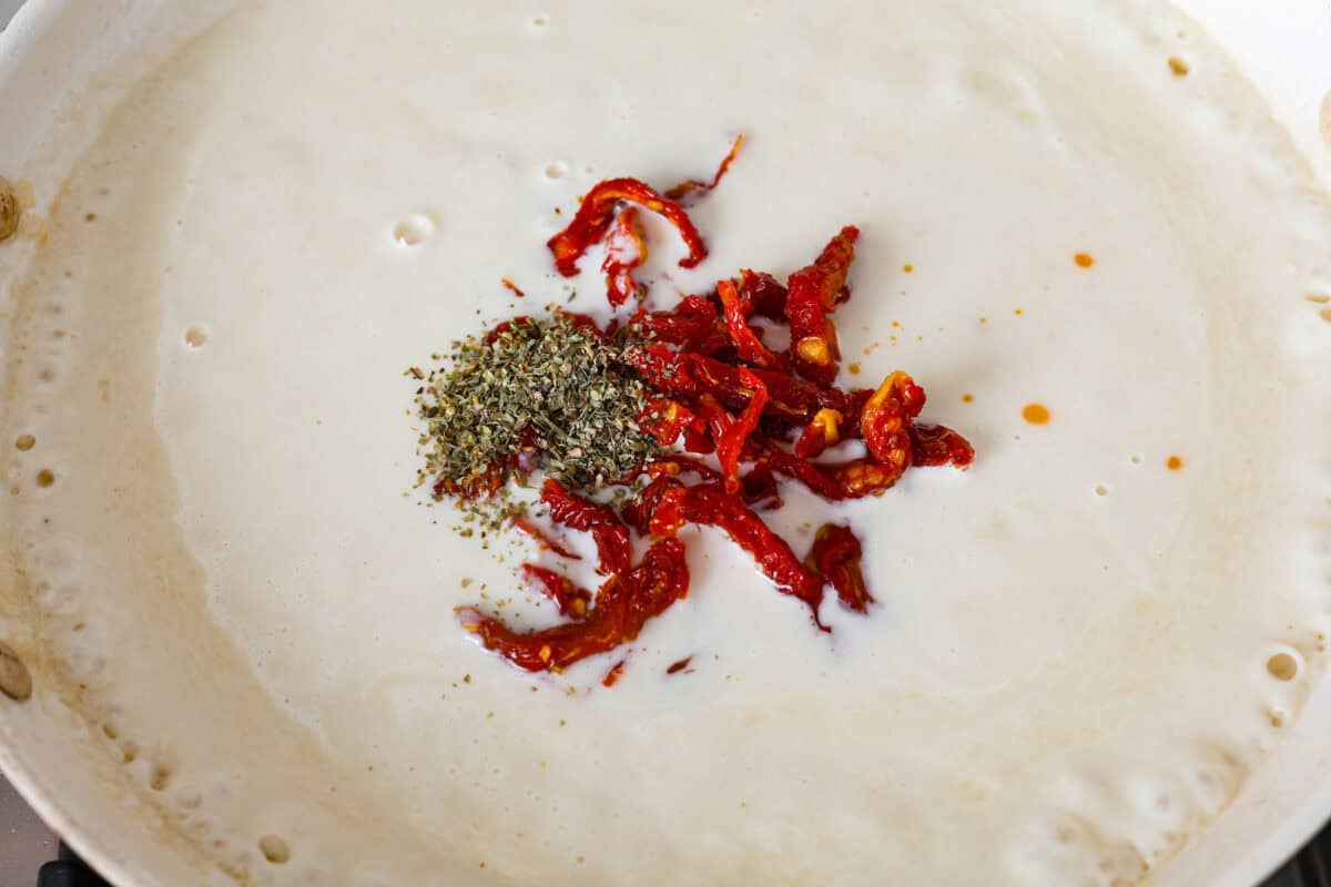 With creamy Tuscan flavors, these Marry Me Meatballs are an instant crowd favorite! It doesn't get much better than Italian seasoned chicken meatballs nestled in a creamy, cheesy sauce with sun-dried tomatoes and fresh herbs. Close up shot of sun-dried tomatoes and Italian seasoning on top of the sauce.