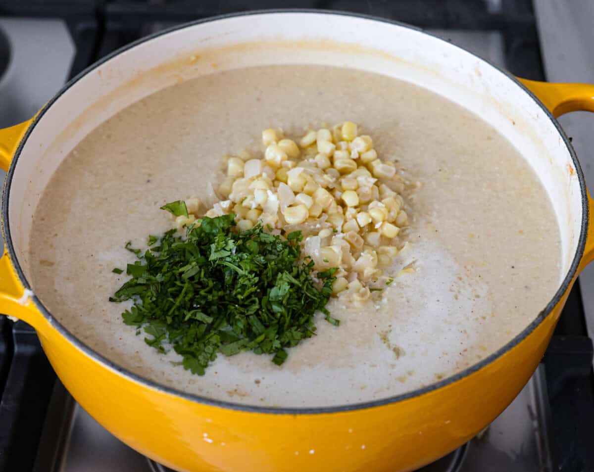Mexican street corn soup has all the incredible flavors of street corn in a warm, comforting, delicious soup. This soup has fresh corn, lots of cotija cheese, spices, cilantro, lime juice, and sour cream to make it smooth and creamy. Angel shot of blended soup with cilantro and extra corn on top.