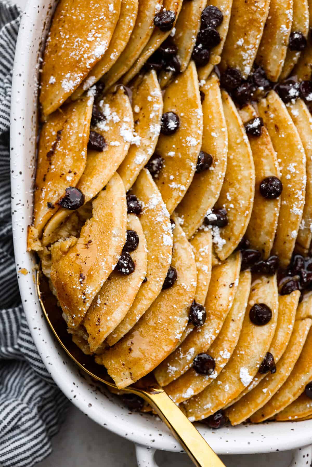 Pancake Casserole is a fun new Christmas or Easter breakfast idea. It has lots of buttery pancakes soaked overnight in a creamy custard, is baked to perfection, and served with your favorite toppings! Close up shot of pancake casserole.