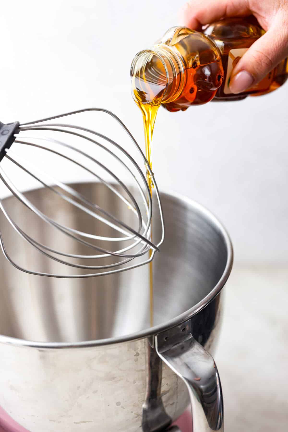 Whipped honey is easy to make but adds a unique and special aspect to something simple. It's soft, sweet, and just tastes better! I love having this on hand to make my kids sandwiches for school. Side shot of someone pouring honey into a stand mixer.