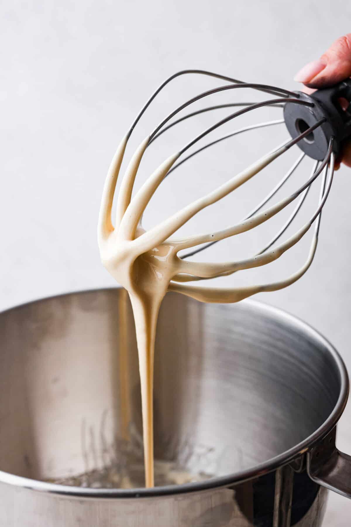 Whipped honey is easy to make but adds a unique and special aspect to something simple. It's soft, sweet, and just tastes better! I love having this on hand to make my kids sandwiches for school. Close up shot of a whisk attachment of a stand mixer dripping with creamed honey.