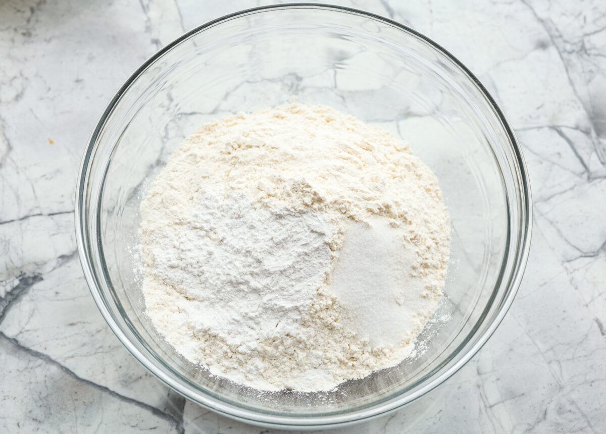 Cream cheese biscuits have a slight twist to the classic version. With the added cream cheese, they have a softer, more fluffy texture with an added tangy flavor that is so good! Overhead shot of dry ingredients in a glass bowl.
