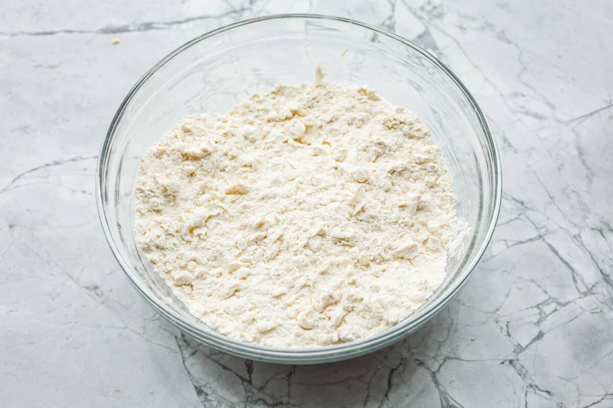 Cream cheese biscuits have a slight twist to the classic version. With the added cream cheese, they have a softer, more fluffy texture with an added tangy flavor that is so good! Overhead shot of flour mixture combined with the butter and cream cheese.