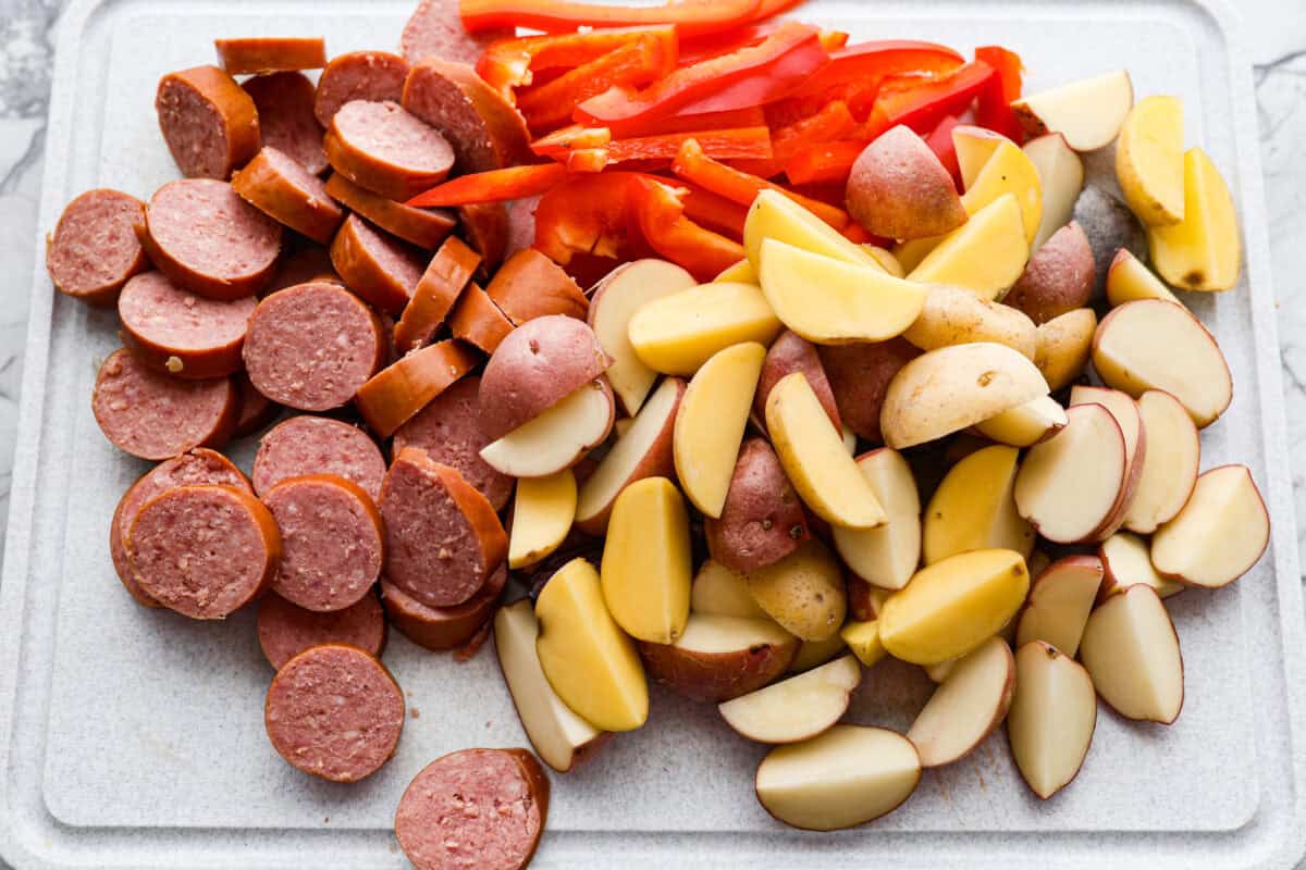 This sausage and potato skillet recipe is meant to be a simple one skillet meal! It has tender baby potatoes, smoked sausage, peppers, and delicious seasonings that take it over the top. It's hearty, satisfying and loaded with flavor! First photo of the sausage, potatoes, and peppers cut.