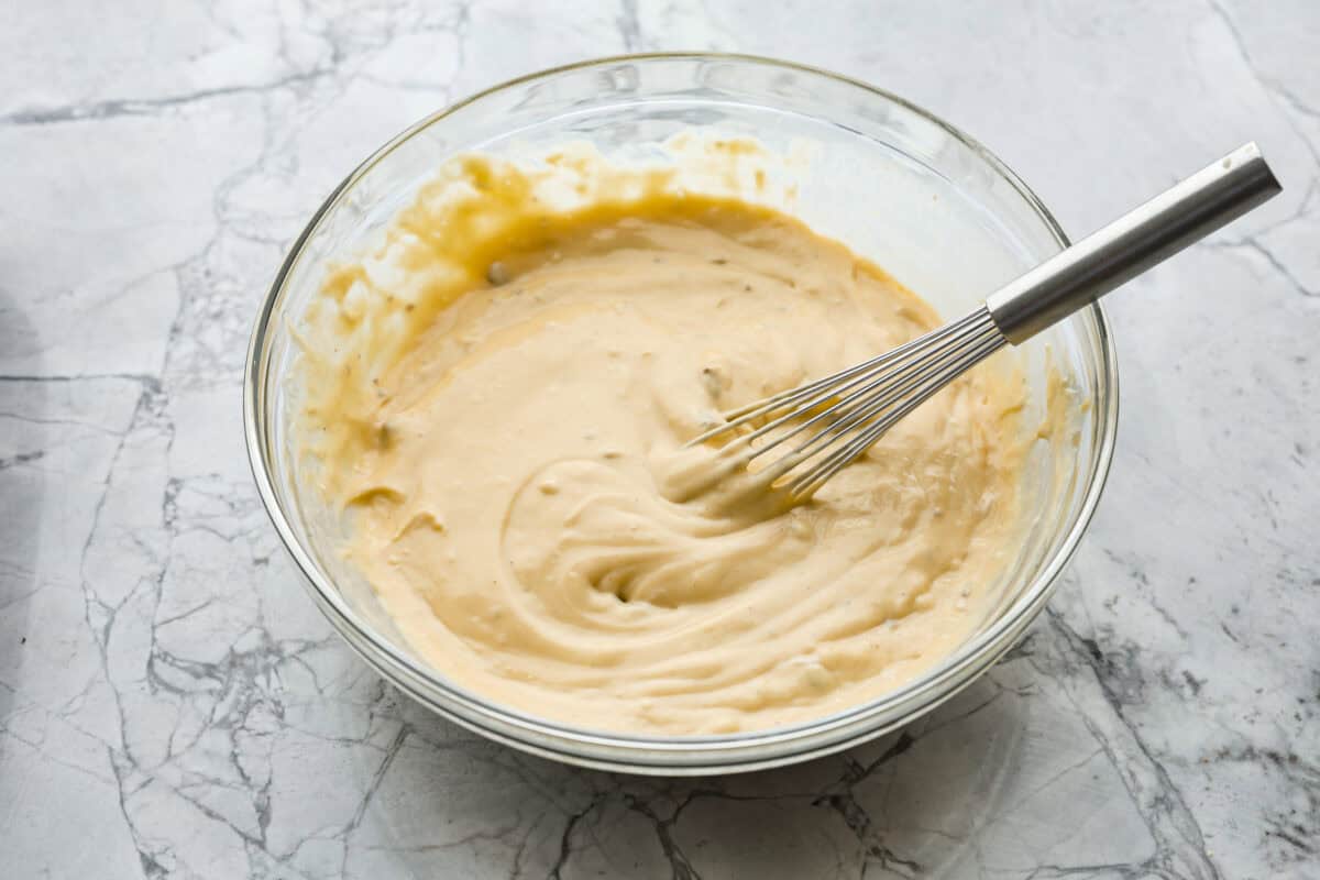 Hamburger Potato Casserole is hearty, filling, and great for family dinners. It's full of tender potatoes and ground beef, smothered in a deliciously creamy sauce, and covered in melty cheese. Overhead shot of soup milk and Worcestershire sauce in a glass bowl.