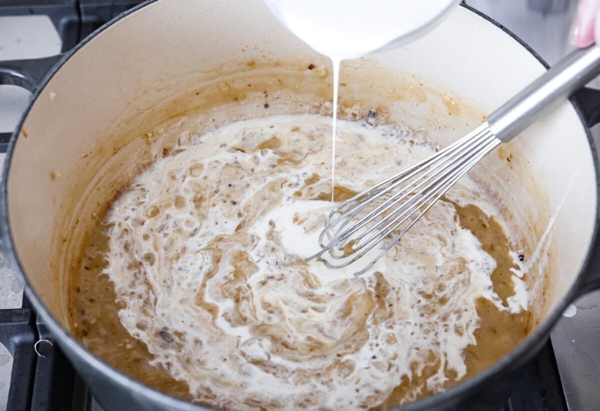 Comforting White Lasagna Soup is warm, creamy, and packed with rich flavors. With its hearty mix of chicken, noodles, white beans, and cheese, it’s a guaranteed crowd-pleaser. Deconstructed white lasagna in a satisfying soup! Angle shot of someone slowly pouring in the chicken broth and heavy cream into the roux in a pot.