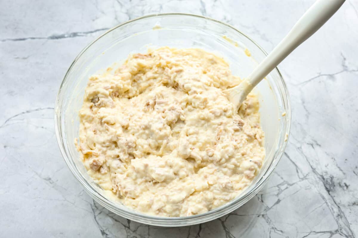 Angel Chicken and Rice Casserole is a creamy, cheesy, comforting classic. Tender chicken is folded into fluffy rice smothered in a savory cream sauce. The top has the most perfectly toasty cheesy crunch. You're going to love it! Overhead shot of chicken and rice mixed with the cream sauce mixture.