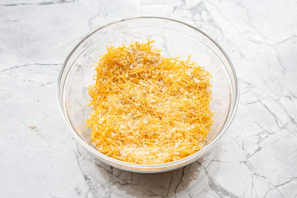 Angel Chicken and Rice Casserole is a creamy, cheesy, comforting classic. Tender chicken is folded into fluffy rice smothered in a savory cream sauce. The top has the most perfectly toasty cheesy crunch. You're going to love it! Overhead shot of cheese, breadcrumbs salt pepper and herbs mixed together in a bowl.