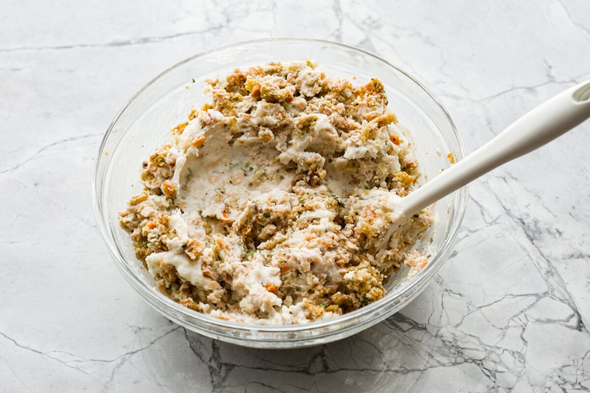 Angle shot of turkey, mashed potatoes, breadcrumbs and stuffing mixed in a bowl.
