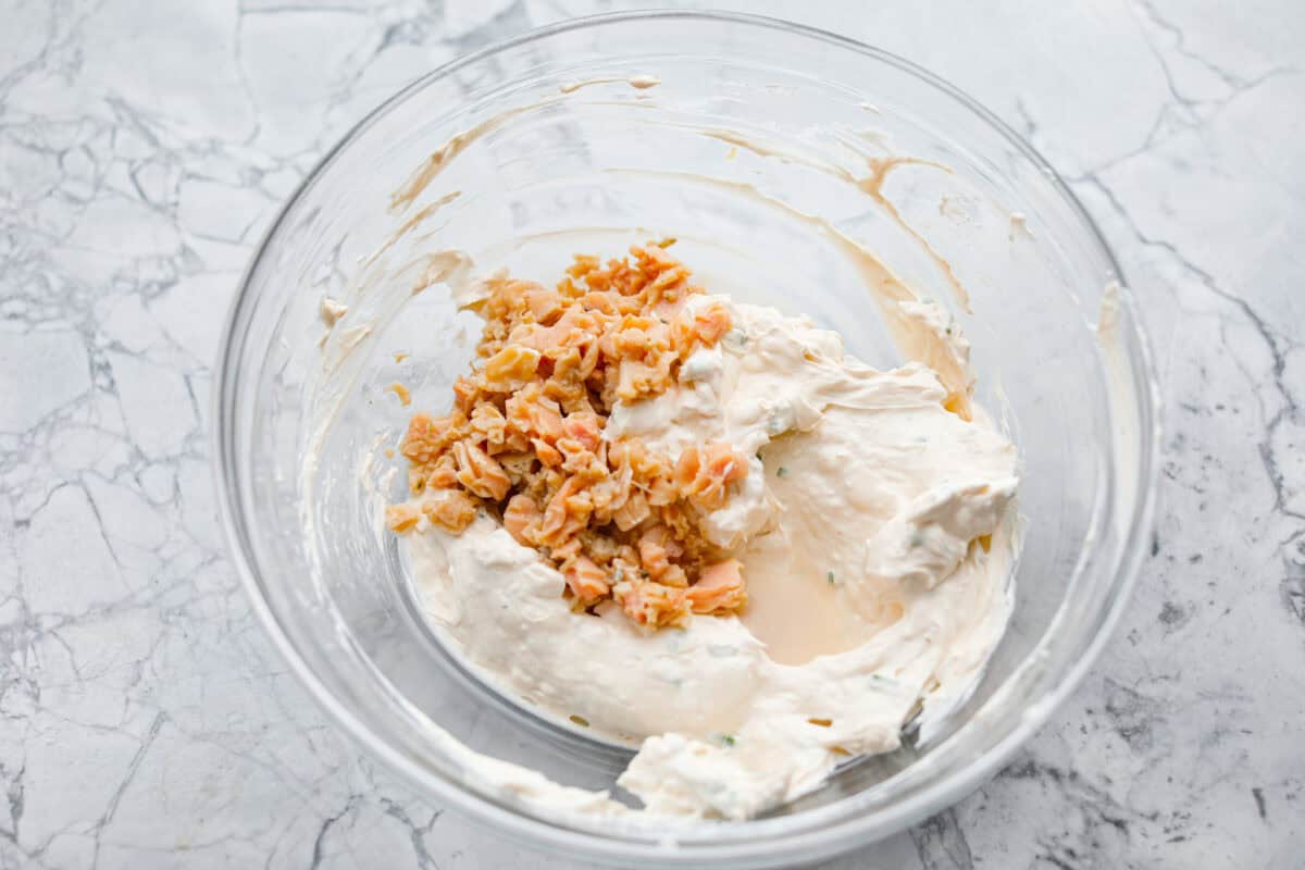 This clam dip is creamy, savory and the ultimate crowd-pleaser for any gathering! Whether paired with crispy chips or fresh veggies, it’s a quick and easy recipe that tastes incredible. Perfect for game day, potlucks, holidays or a casual snack! Overhead shot of dip ingredients mixed together with clams on top.