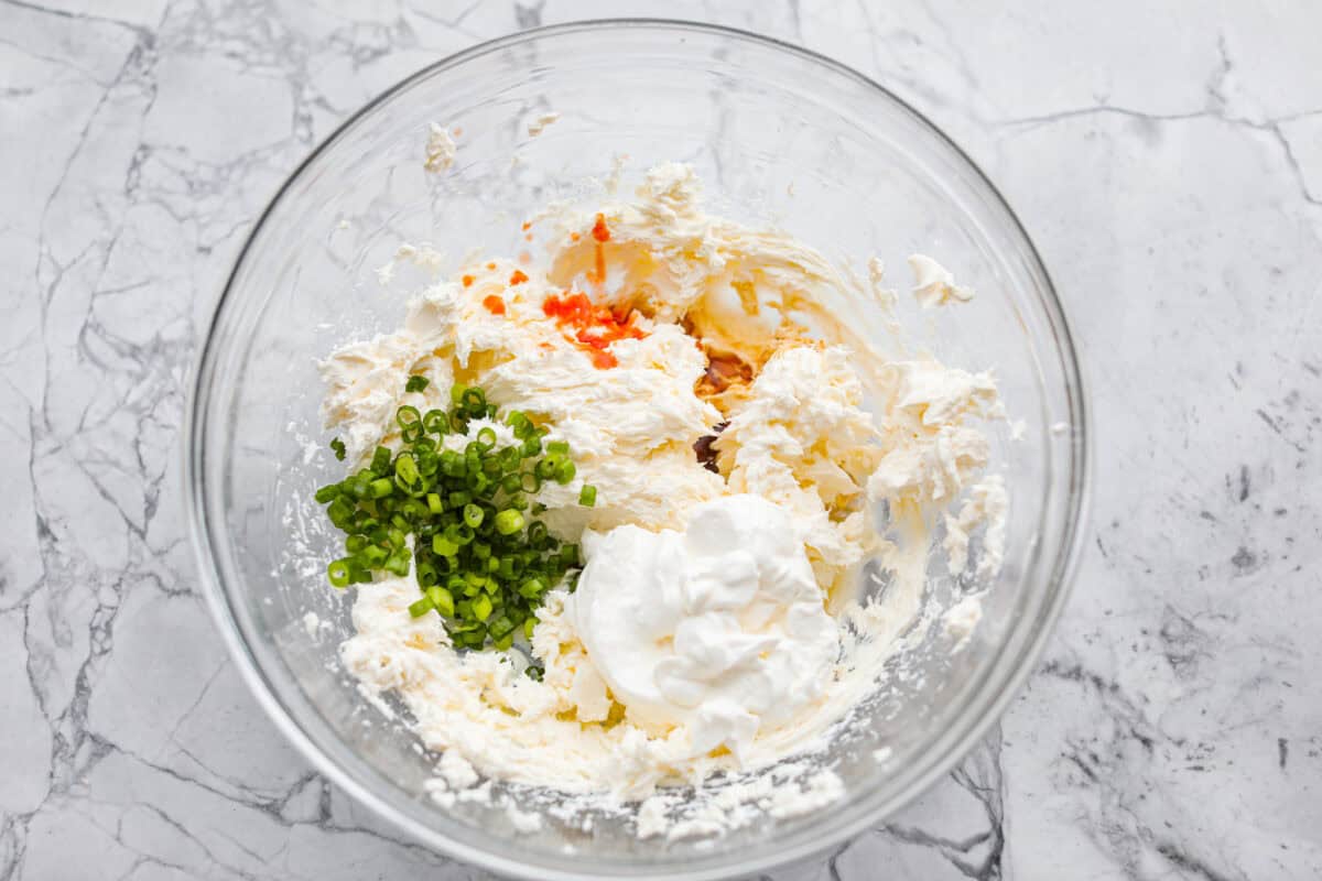 This clam dip is creamy, savory and the ultimate crowd-pleaser for any gathering! Whether paired with crispy chips or fresh veggies, it’s a quick and easy recipe that tastes incredible. Perfect for game day, potlucks, holidays or a casual snack! Overhead shot of ingredients in a bowl.