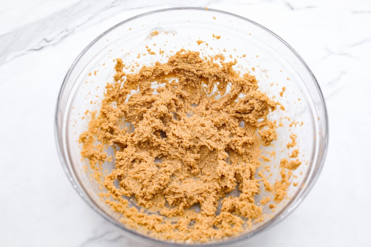 You will absolutely adore these Coffee Cake Cookies! They are loaded with that classic cinnamon sugar flavor, and the crumbly cinnamon streusel is to die for. It’s the perfect treat to enjoy at a special brunch, for the holidays, or a sweet treat for any night of the week. Overhead shot of butter and sugars mixed in a glass bowl.