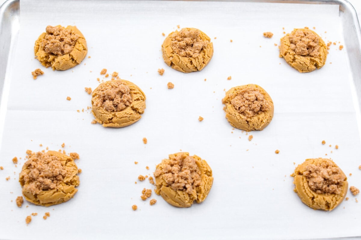 You will absolutely adore these Coffee Cake Cookies! They are loaded with that classic cinnamon sugar flavor, and the crumbly cinnamon streusel is to die for. It’s the perfect treat to enjoy at a special brunch, for the holidays, or a sweet treat for any night of the week. Overhead shot of the coffee cake cookie dough with streusel sprinkled over the top, on parchment paper ready to go in the oven.