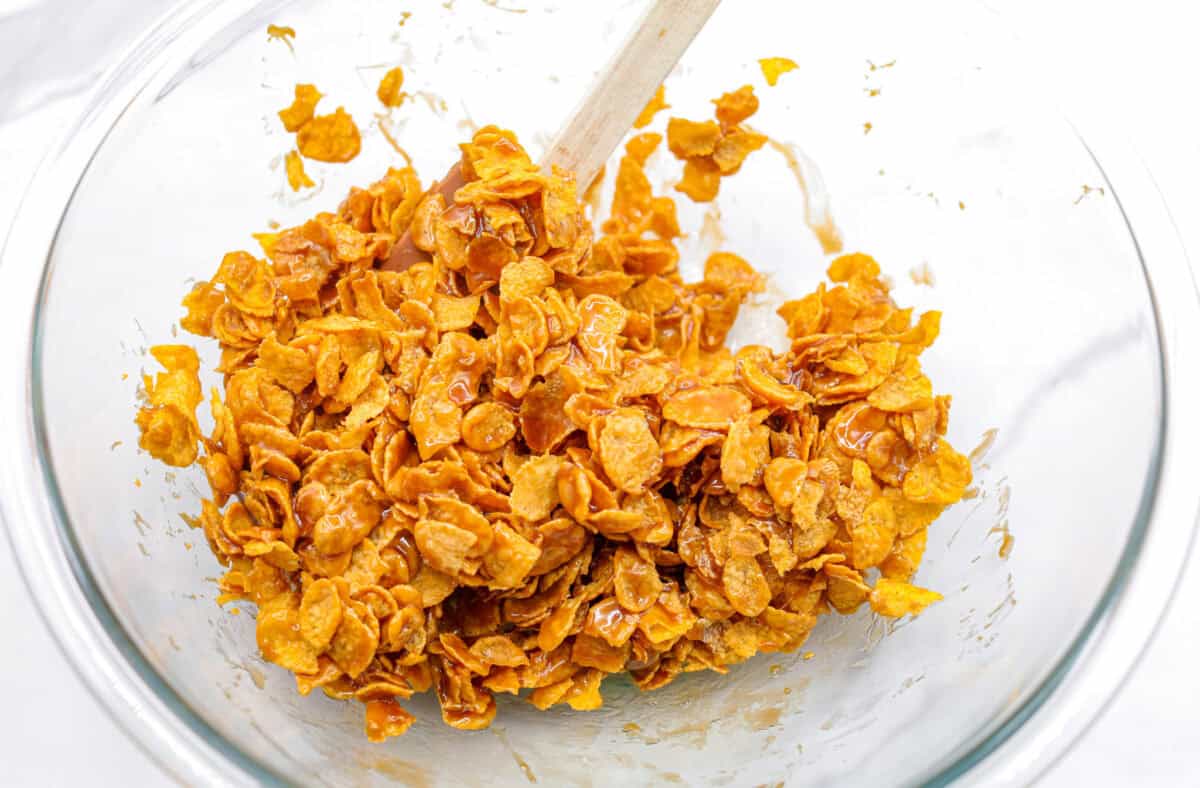 This cornflake brittle crack is crispy, chewy and to die for! With only six ingredients and 8 minutes of prep, you can have this yummy treat ready in no time. This brittle is crunchy cornflakes mixed with a buttery caramel sauce and drizzled in rich dark chocolate. Overhead shot of cornflakes mixed with the butter and sugar mixture.