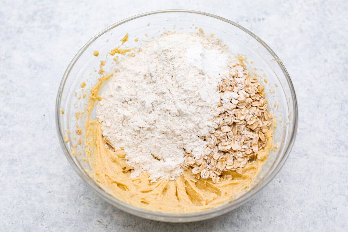 Delicious and addicting, the famous Crack Pie is what made Milk Bar bakery so popular. This copycat recipe is made with a sweet and salty filling tucked inside a crispy oat cookie crust. It’s so good you won’t be able to stop eating it! Overhead shot of butter mixture with oats, flour, baking powder, baking soda and salt on top.