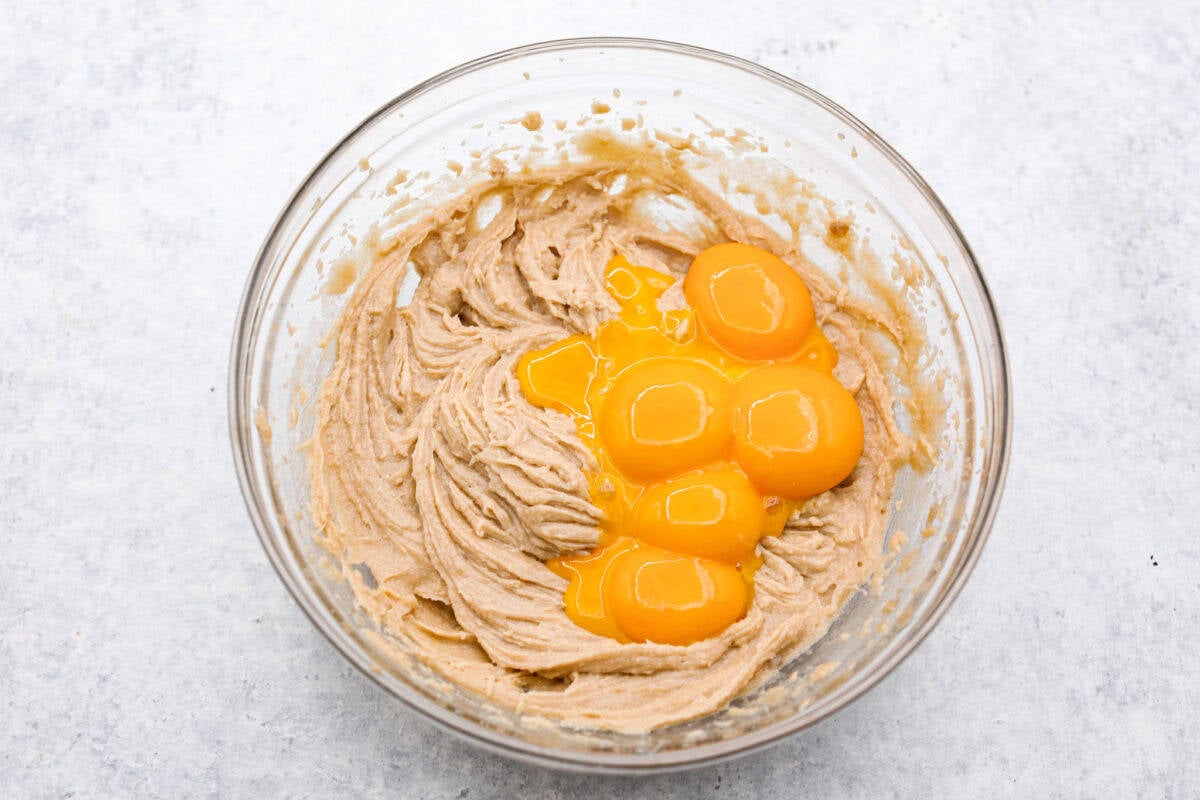 Delicious and addicting, the famous Crack Pie is what made Milk Bar bakery so popular. This copycat recipe is made with a sweet and salty filling tucked inside a crispy oat cookie crust. It’s so good you won’t be able to stop eating it! Overhead shot of crack pie filling with egg yolks in a glass bowl.