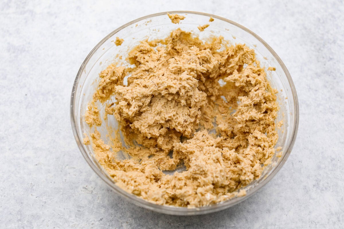 Delicious and addicting, the famous Crack Pie is what made Milk Bar bakery so popular. This copycat recipe is made with a sweet and salty filling tucked inside a crispy oat cookie crust. It’s so good you won’t be able to stop eating it! Overhead shot of cookie dough mixed in a bowl.