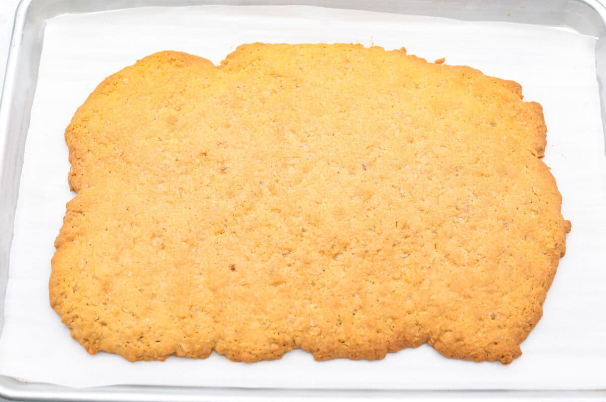 Delicious and addicting, the famous Crack Pie is what made Milk Bar bakery so popular. This copycat recipe is made with a sweet and salty filling tucked inside a crispy oat cookie crust. It’s so good you won’t be able to stop eating it! Overhead shot of baked rectangular oatmeal cookie slab.