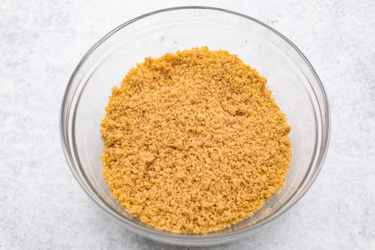 Delicious and addicting, the famous Crack Pie is what made Milk Bar bakery so popular. This copycat recipe is made with a sweet and salty filling tucked inside a crispy oat cookie crust. It’s so good you won’t be able to stop eating it! Overhead shot of crust ingredients mixed in a glass bowl.