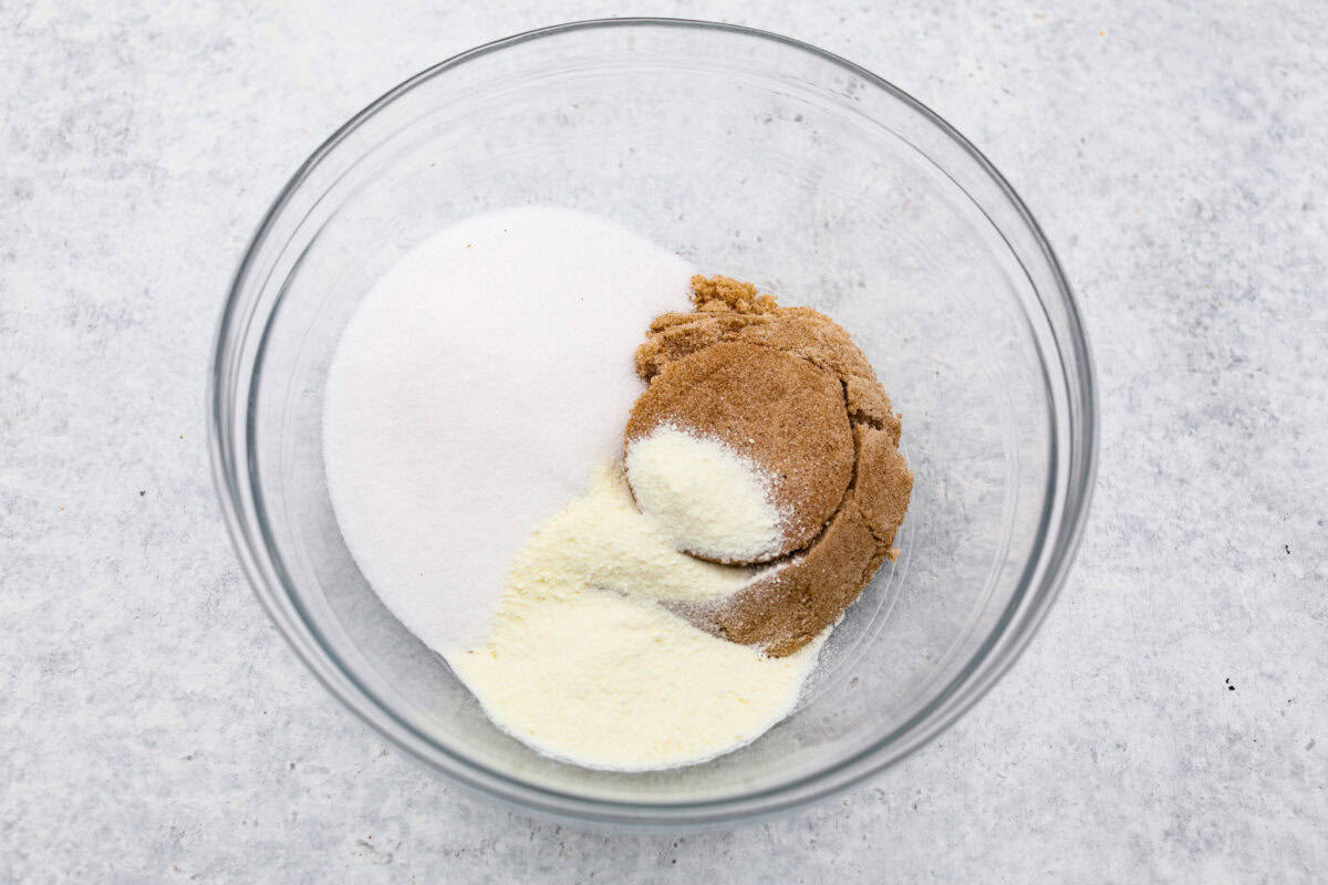 Delicious and addicting, the famous Crack Pie is what made Milk Bar bakery so popular. This copycat recipe is made with a sweet and salty filling tucked inside a crispy oat cookie crust. It’s so good you won’t be able to stop eating it! Overhead shot of sugars and milk powder in a glass bowl.