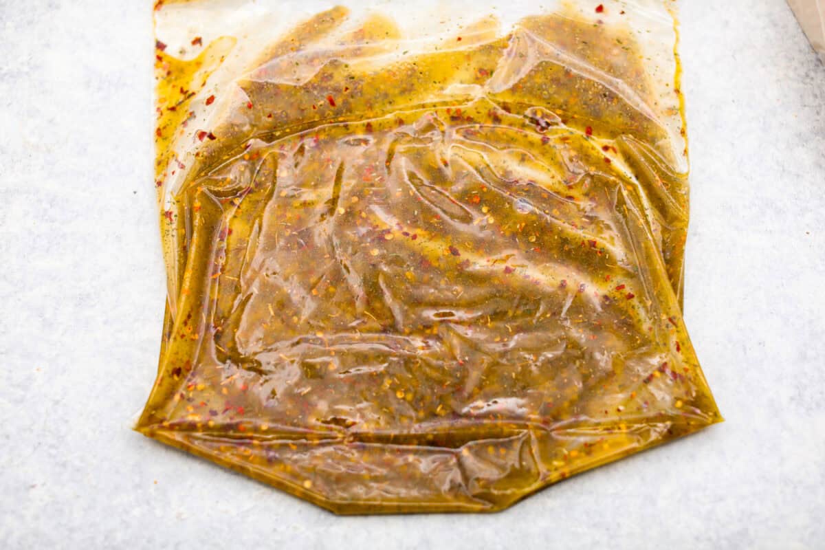 Get the party started with Fire Crackers! In this recipe, saltine crackers are transformed from something ordinary into something extraordinary with a flavorful blend of seasonings. They're easy to make and perfect for snacking on around the holidays (or anytime)! Overhead shot of a ziplock bag laying on its side with all of the ingredients inside mixed up.