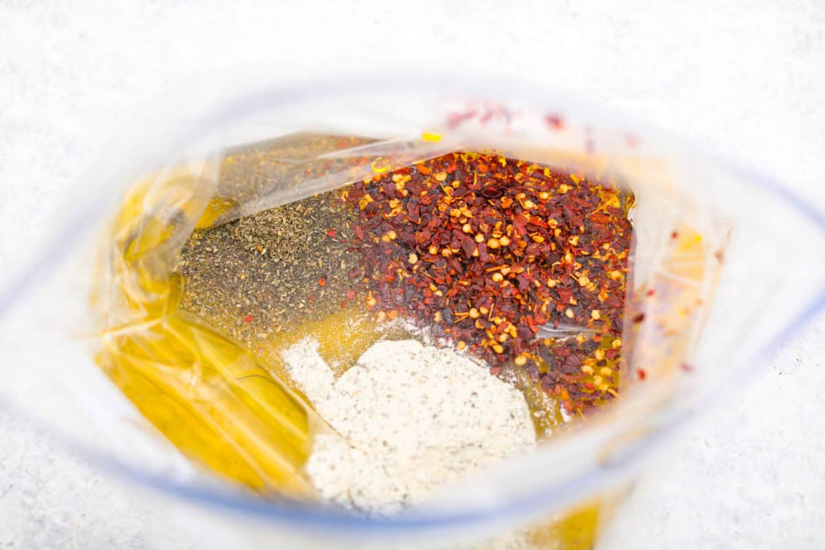 Get the party started with Fire Crackers! In this recipe, saltine crackers are transformed from something ordinary into something extraordinary with a flavorful blend of seasonings. They're easy to make and perfect for snacking on around the holidays (or anytime)! Overhead shot of all of the ingredients in a ziplock bag.