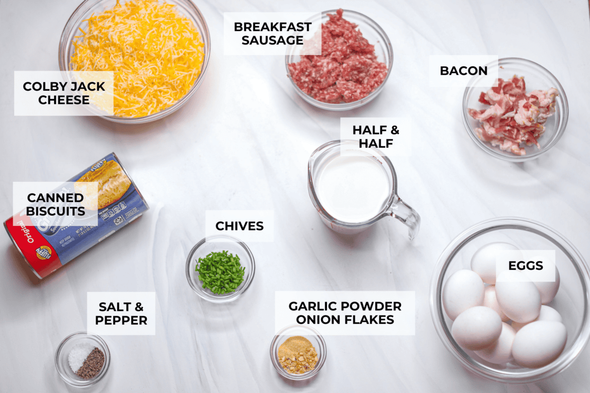This bubble up breakfast casserole is simple to prepare and super flavorful! It's made with layers of biscuit, crispy bacon, savory sausage, fluffy eggs and melty cheese. Everyone will get out of bed and run to the breakfast table for this yummy dish! Overhead shot of labeled ingredients.