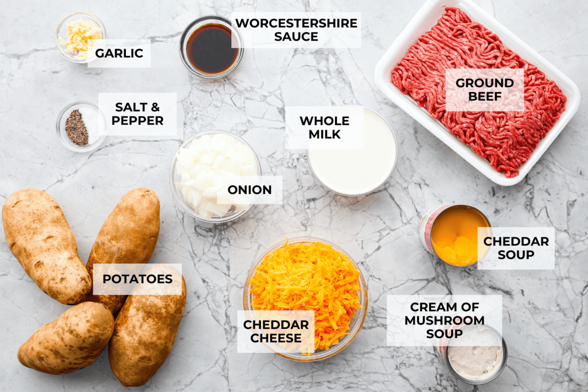 Hamburger Potato Casserole is hearty, filling, and great for family dinners. It's full of tender potatoes and ground beef, smothered in a deliciously creamy sauce, and covered in melty cheese. Overhead shot of labeled ingredients.