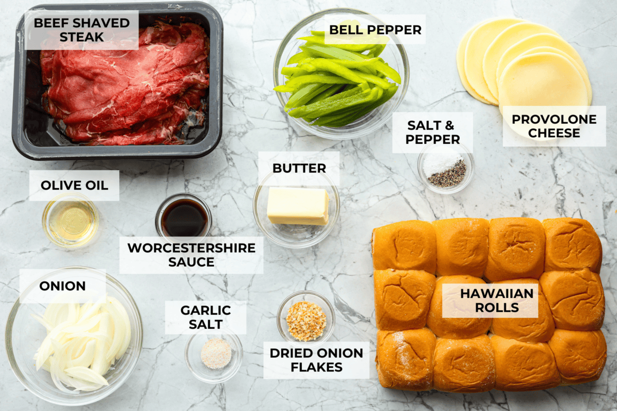 Philly cheesesteak sliders are a fun and delicious twist on a classic. These Philly cheesesteaks are filled with thinly sliced steak, caramelized onions, crisp peppers, and, of course, melty cheese. Overhead shot of labeled ingredients.