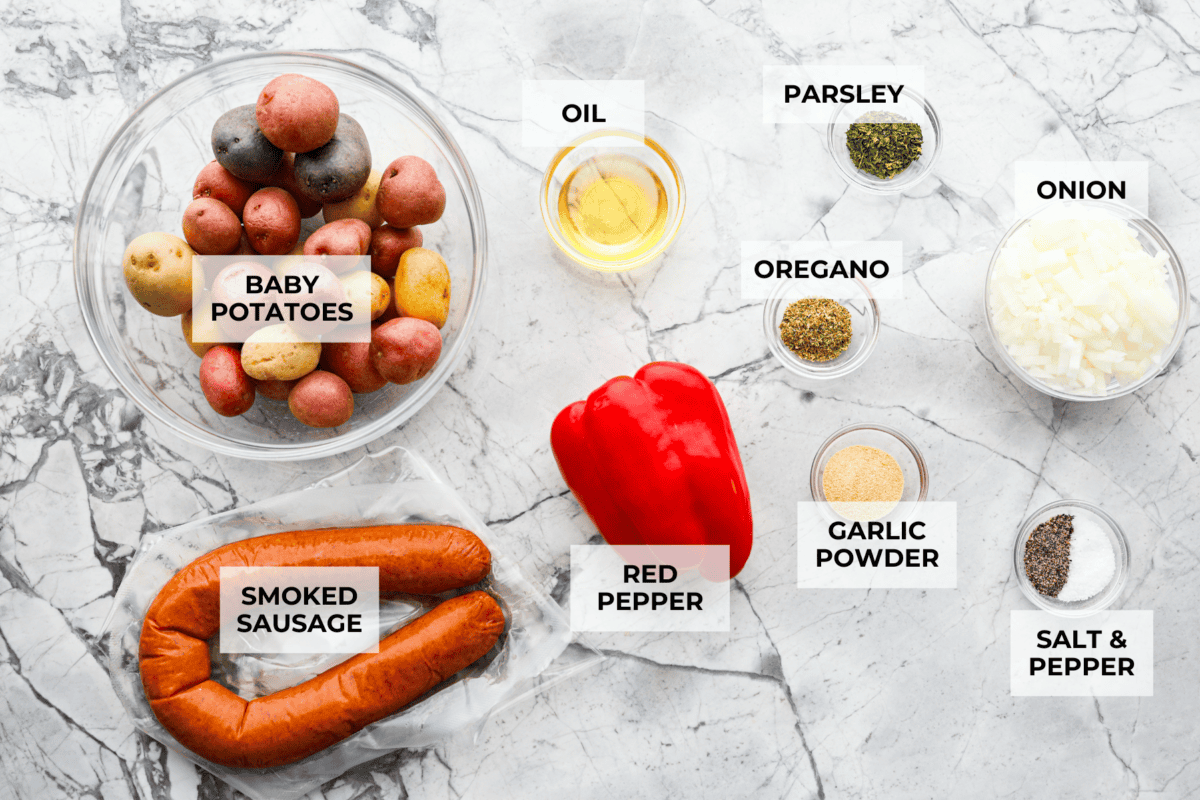 This sausage and potato skillet recipe is meant to be a simple one skillet meal! It has tender baby potatoes, smoked sausage, peppers, and delicious seasonings that take it over the top. It's hearty, satisfying and loaded with flavor! Ingredients layer out and labeled.