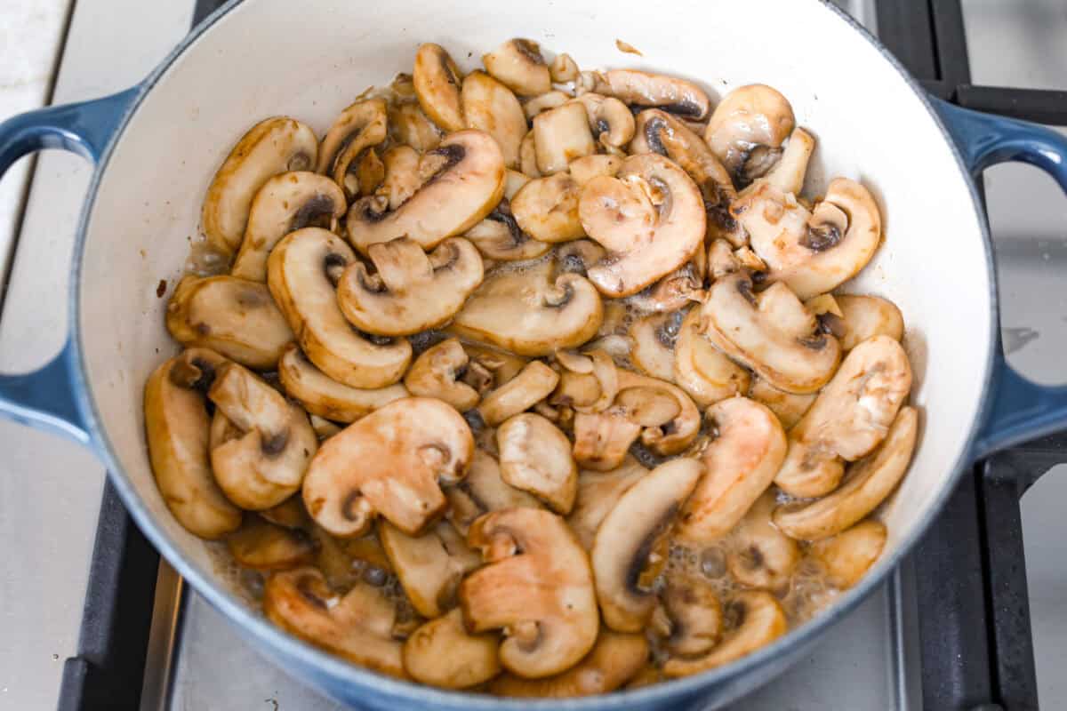 Mushroom bisque is full of cream and garlic-infused mushrooms, all blended to make a thick, rich, and beyond flavorful soup! You will want to drink this straight from your bowl! Overhead shot of mushrooms sautéing in a skillet.
