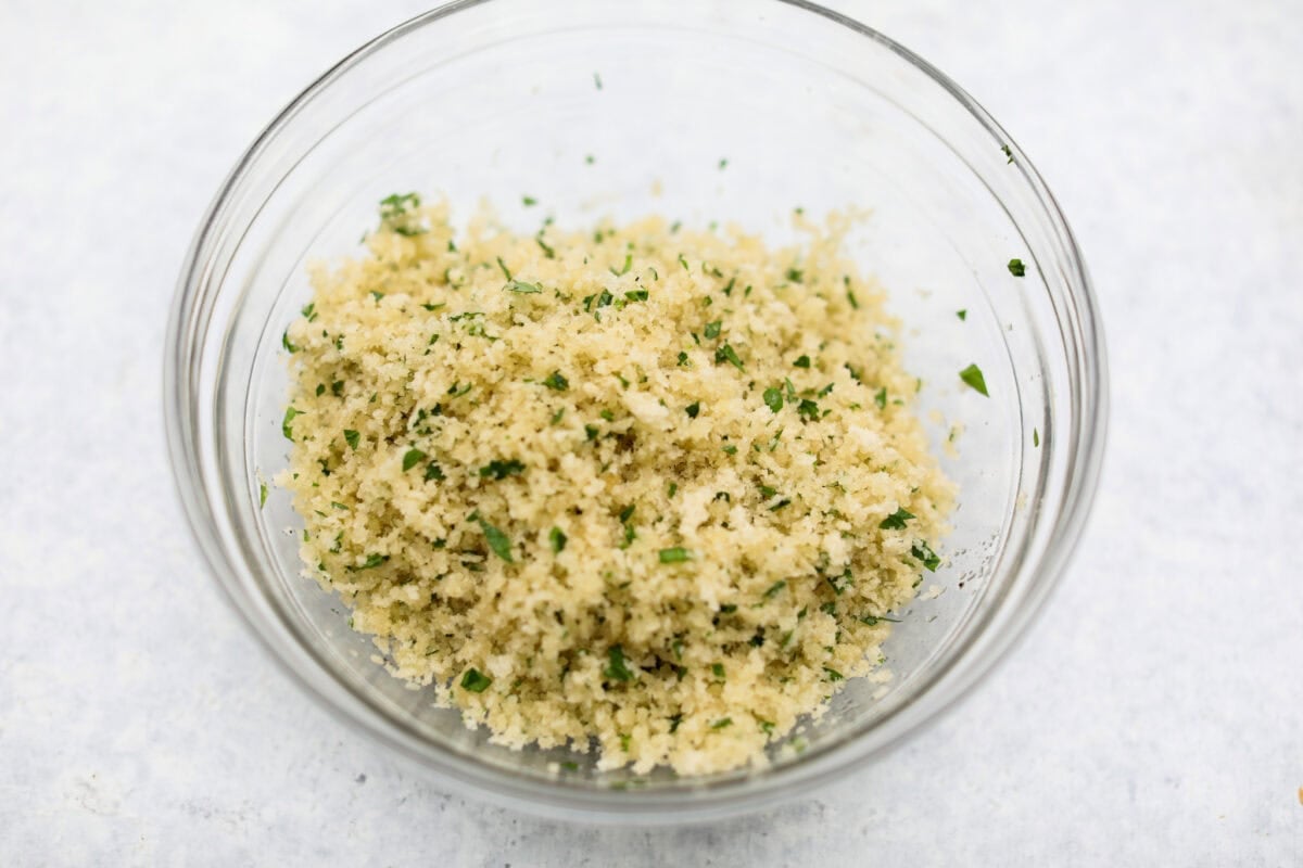 This creamy Mushroom Casserole is an impressive side dish to any meal! It's loaded with tender mushrooms mixed in a cheesy decadent sauce, then baked with a panko herb topping. Fifth photo of breadcrumb topping in a bowl.