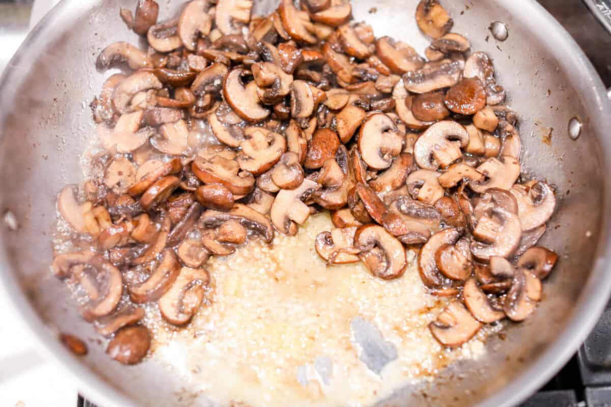 This creamy Mushroom Casserole is an impressive side dish to any meal! It's loaded with tender mushrooms mixed in a cheesy decadent sauce, then baked with a panko herb topping. Second photo of the butter and garlic added to the skillet.