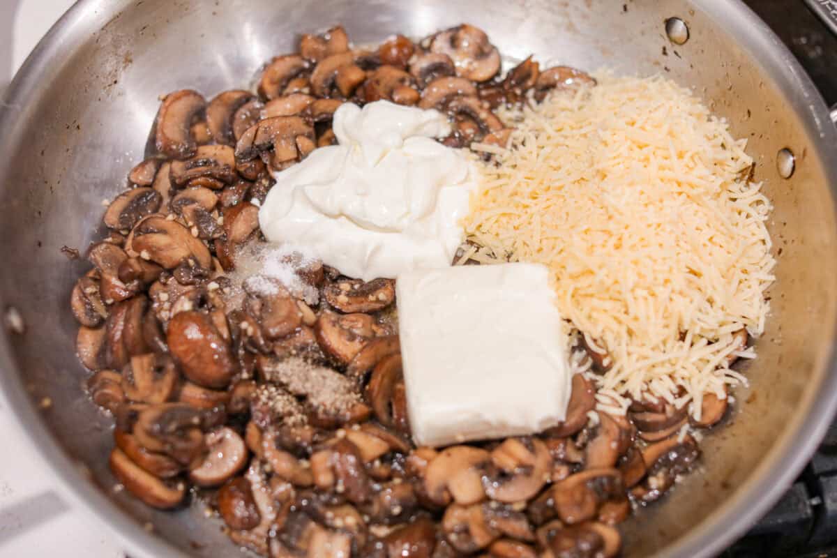 This creamy Mushroom Casserole is an impressive side dish to any meal! It's loaded with tender mushrooms mixed in a cheesy decadent sauce, then baked with a panko herb topping. Third photo of the cheeses added to the skillet.