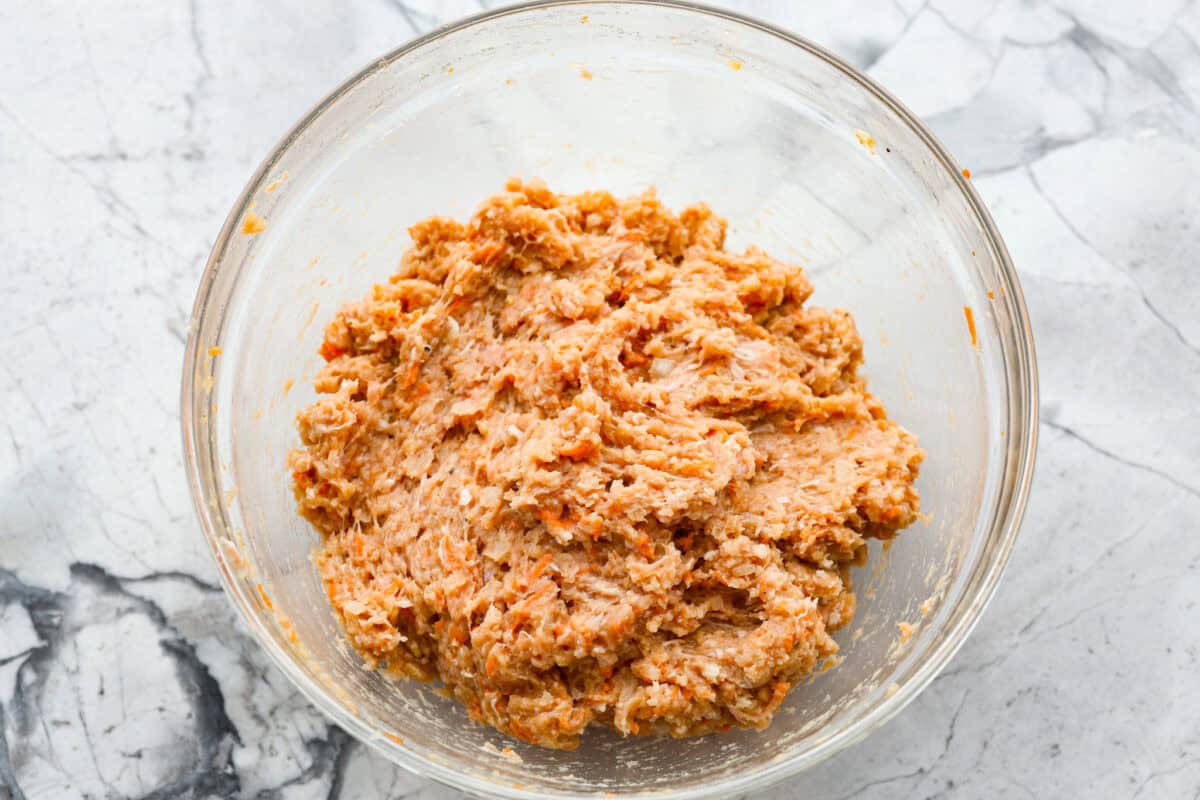 Easy Bola Bola (Filipino meatballs) combine pork, panko breadcrumbs, carrots, and onions to create a versatile meatball recipe. Tender and tasty on the inside then deep-fried and crispy on the outside! The perfect appetizer or dinner idea! Second photo of the bola bola ingredients mixed in a bowl.