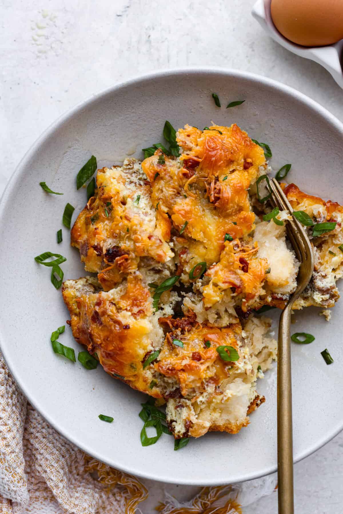 This bubble up breakfast casserole is simple to prepare and super flavorful! It's made with layers of biscuit, crispy bacon, savory sausage, fluffy eggs and melty cheese. Everyone will get out of bed and run to the breakfast table for this yummy dish! Overhead shot of plated bubble up breakfast casserole.
