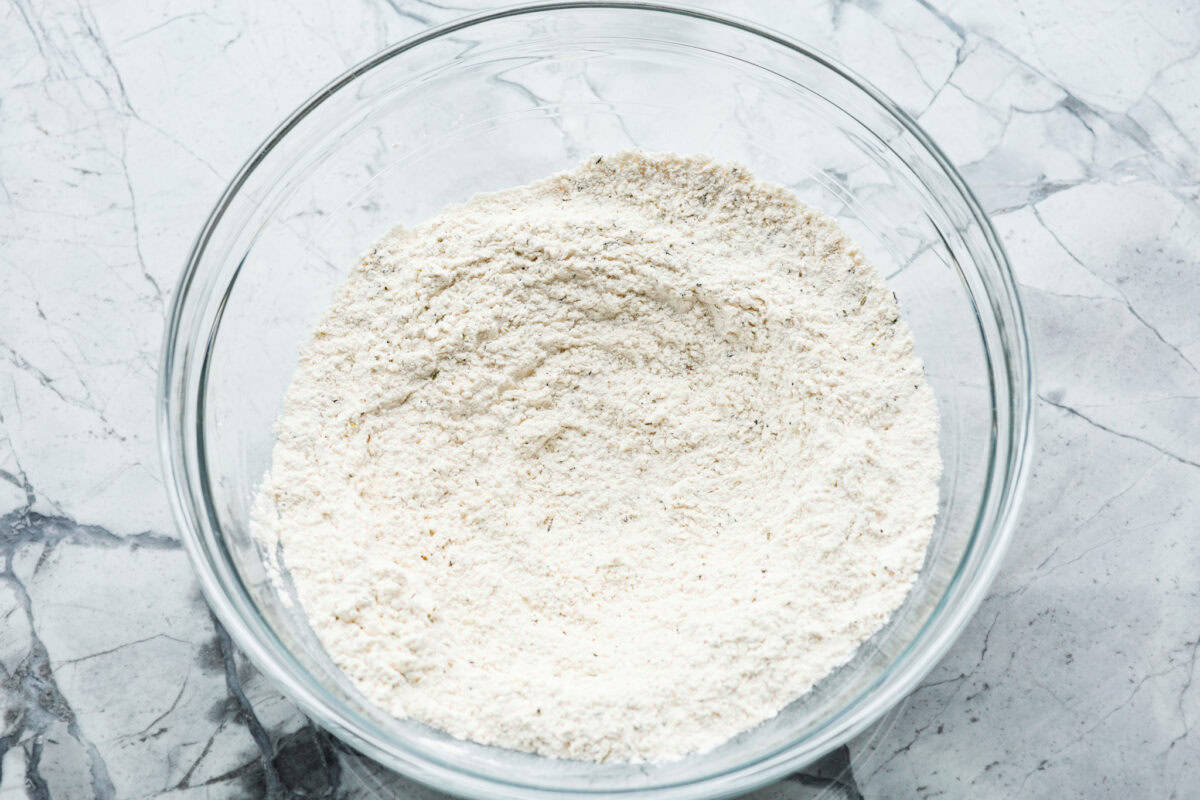 Easy Cheesy Quick Bread is packed with flavor and has a tender, golden crust and soft, moist interior. It's perfect with soup, salad, chili, or on its ownย with a pat of butter. It's simple to make and irresistibly delicious! Overhead shot of dry ingredients in a bowl.