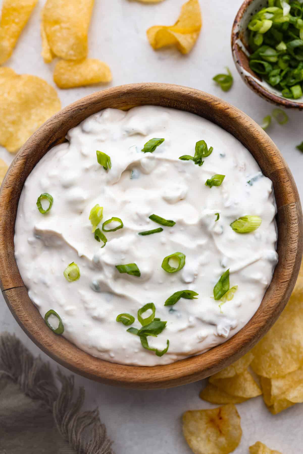 This clam dip is creamy, savory and the ultimate crowd-pleaser for any gathering! Whether paired with crispy chips or fresh veggies, it’s a quick and easy recipe that tastes incredible. Perfect for game day, potlucks, holidays or a casual snack! Close up shot of clam dip.