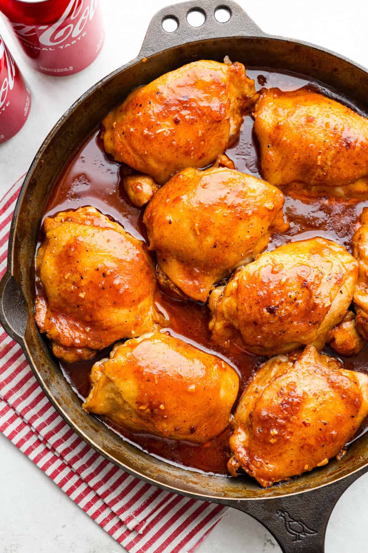 This incredibly tasty Coca-Cola chicken thigh recipe can be on the table in 40 minutes. The succulent sauce is a combination of savory soy sauce, Worcestershire, garlic, ketchup, and, of course, Coca-Cola. You've never had more flavorful chicken thighs than these! Overhead shot of coca-cola chicken in a skillet.