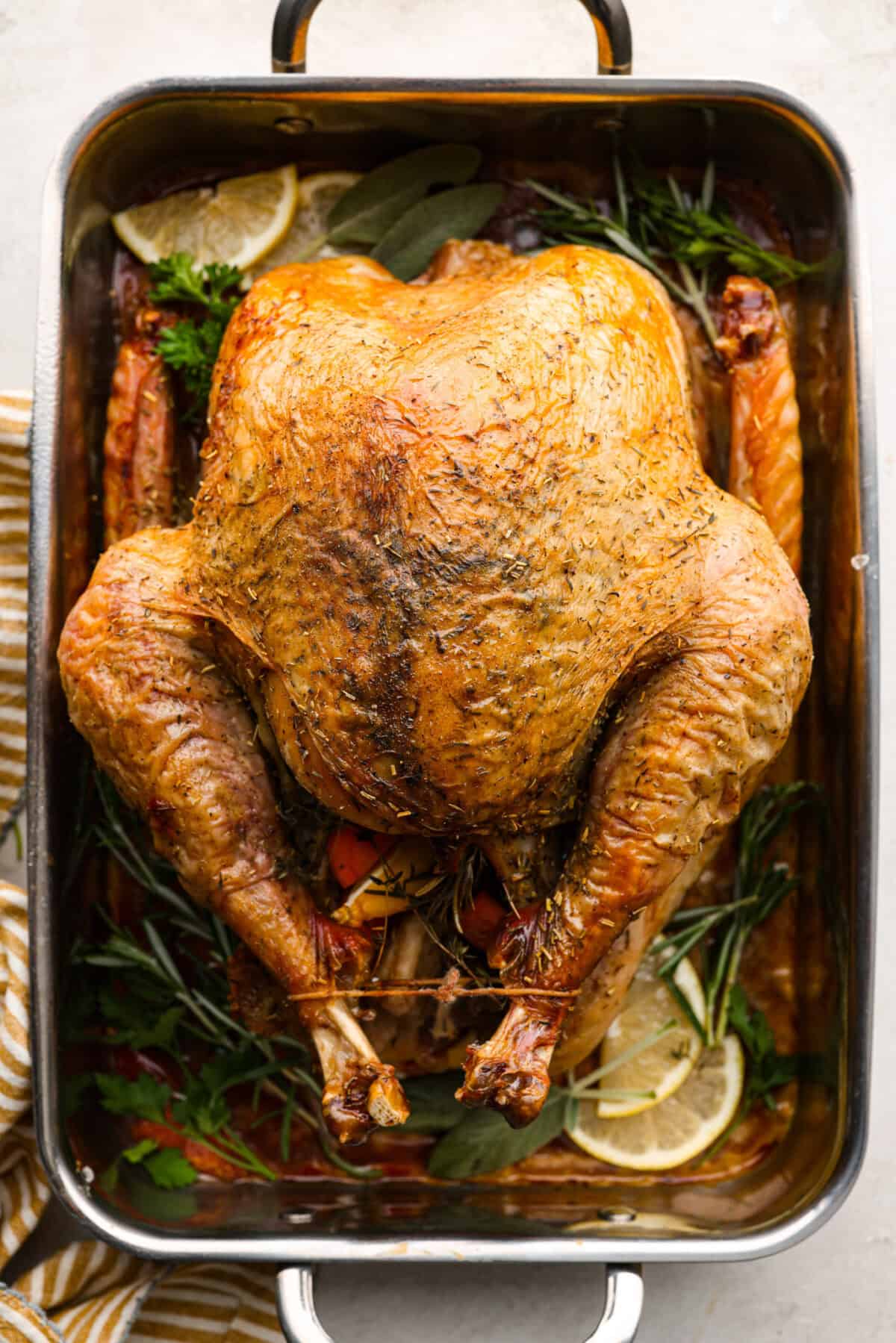 When you dry brine your turkey, you end up with a beautifully browned bird with crispy skin on the outside and juicy, flavorful meat on the inside! It will for sure be one of the most flavorful, moist turkeys you've ever had! Overhead shot of dry brine turkey in a roasting pan.